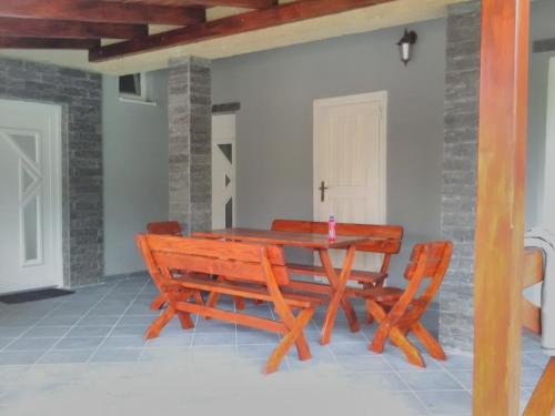 a wooden table and chairs on a patio at Apartman Silver in Zádiel