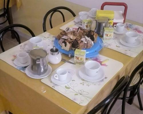 a table with plates and cups and desserts on it at B&B Luna in Valmontone