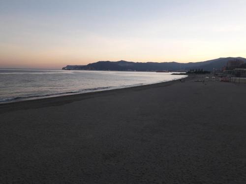 a view of the beach at sunset at Skyline, Casa Vacanze in Savona
