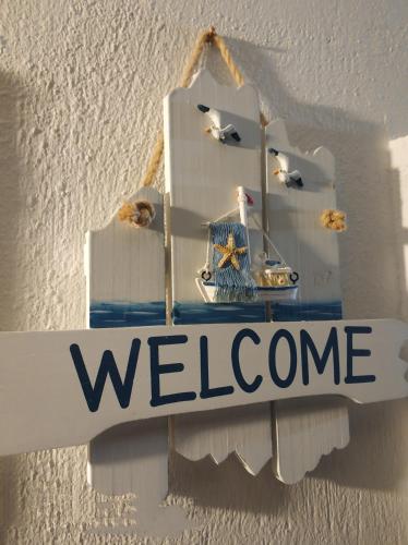 a welcome sign hanging on a wall with a welcome sign at Agapi Villas in Karterados