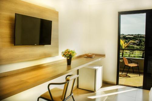 a home office with a desk and a television at Hotel Recreio São Jorge in Jaboticabal