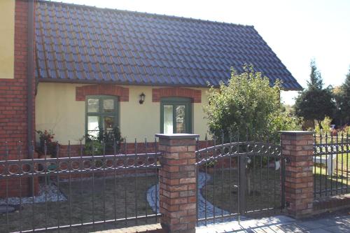 a house with a black fence and a gate at Ferienwohnung Zum Alten Gaswerk in Gräfenhainichen