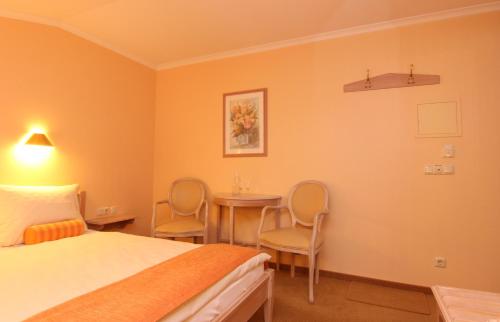 a hotel room with a bed and a table and chairs at Rabenauer Mühle "bed & breakfast" in Rabenau