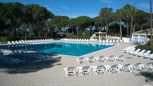 une piscine avec des chaises longues et un tas de meubles dans l'établissement Résidence Valescure, à Saint-Raphaël
