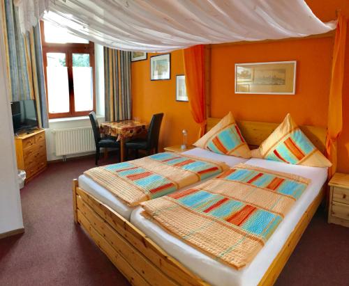 um quarto com uma cama grande e paredes cor-de-laranja em Pension Holzhausen em Quedlinburg