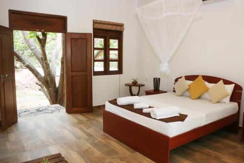 1 dormitorio con 1 cama con sábanas y almohadas blancas en Bissa Villa, en Habarana