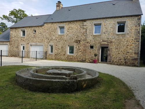 a stone building with a stone circle in front of it at Les Gîtes d'Herquetot -" Les Bruyères" in Vasteville