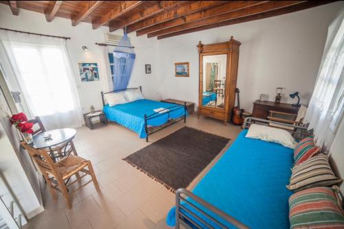 a bedroom with a blue bed and a table at Greek Island Charming Studio in Amorgos