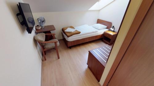 a small bedroom with a bed and a desk at Noclegi Czarna Perła in Kraków