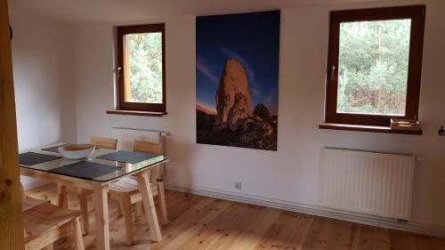 a dining room with a table and two windows at Kompleks Małe Dolomity in Hucisko