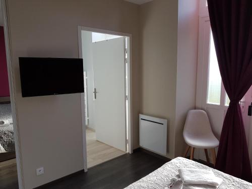 ein Schlafzimmer mit einer Tür mit einem TV und einem Spiegel in der Unterkunft Hotel de la Gare in Dol-de-Bretagne