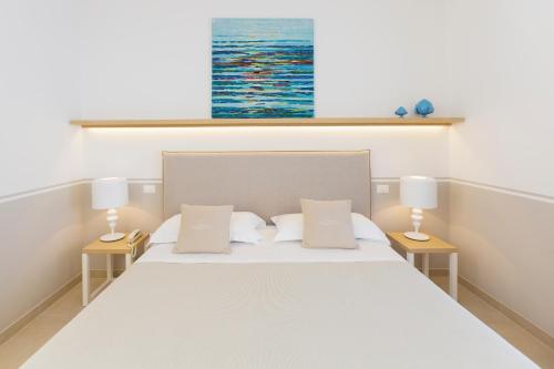 a bedroom with a large bed with two lamps at Giardino Dei Pini - Boutique Hotel in Alliste