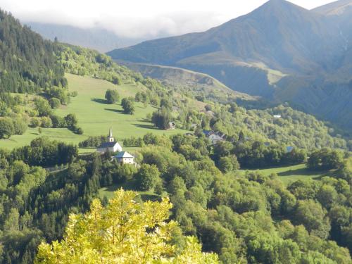 une église au milieu d'une vallée avec des montagnes dans l'établissement L'Epicéa, à Saint-Jean-dʼArves