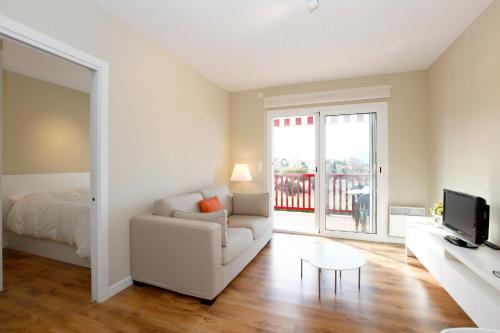 アンダイエにあるLuxury apartment with sea view in Hendaye (France)のリビングルーム(ソファ、ベッド、テレビ付)