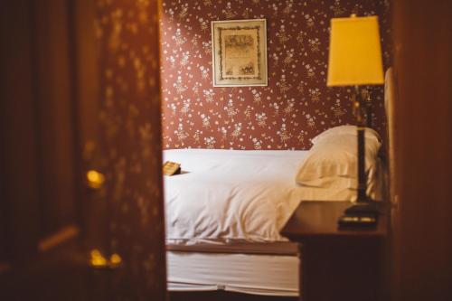 a bedroom with a bed and a lamp and a mirror at Albergo Allegria Hotel & Breakfast Restaurant in Windham