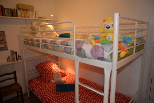 ein Etagenbett mit ausgestopften Tieren und einem Stuhl in einem Zimmer in der Unterkunft La Victoire in Granville