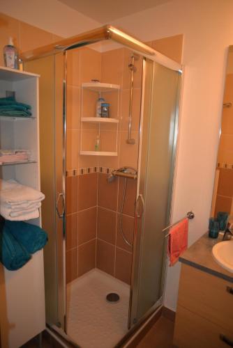 une douche avec une porte vitrée dans une salle de bain dans l'établissement La Victoire, à Granville