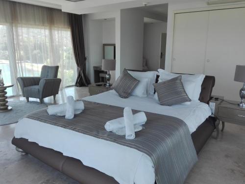 - une chambre avec un grand lit et des serviettes blanches dans l'établissement Egesu Marina Guest House, à Gulluk