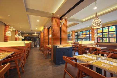 a restaurant with wooden chairs and tables and tablesktop at SAAS Residency in Kozhikode