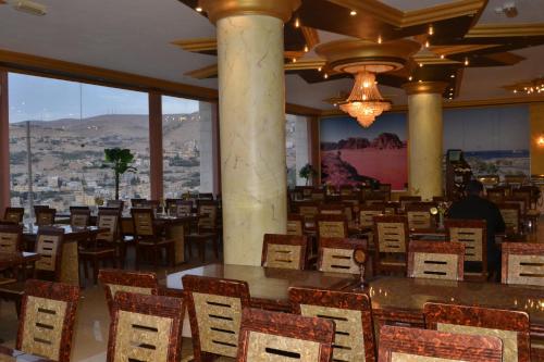 a dining room with tables and chairs and a view at Oscar Hotel Petra in Wadi Musa