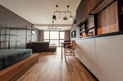 a kitchen and living room with a bed and a table at Porta Batumi Tower in Batumi