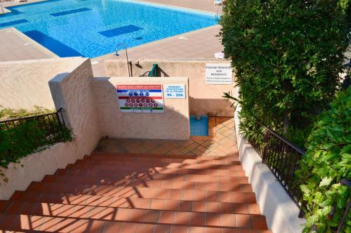 un escalier menant à une piscine avec un panneau dans l'établissement Apartment Eden Park, à Saint-Tropez
