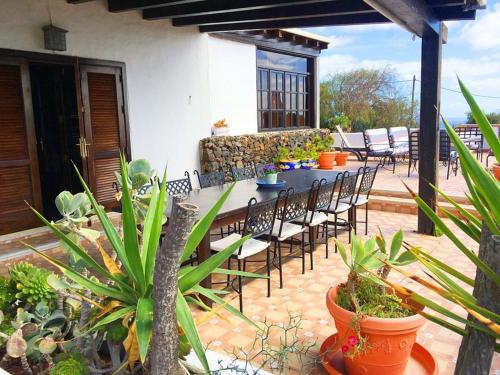 a patio with a table and chairs and plants at Casa Tara - 5 bedroom, 4 bathroom villa with private pool in Mácher