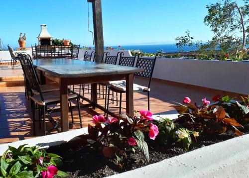 a table and chairs on a balcony with flowers at Casa Tara - 5 bedroom, 4 bathroom villa with private pool in Mácher