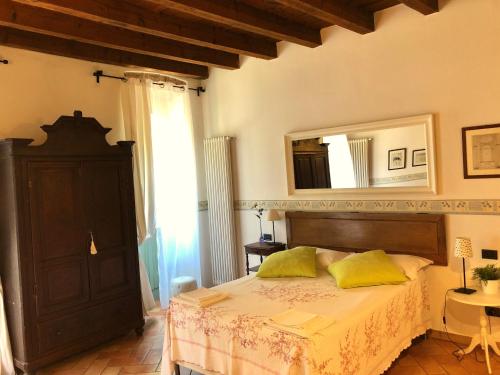 um quarto com uma cama com almofadas amarelas e um espelho em I Balconcini em Bérgamo