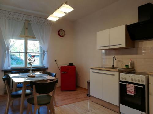 eine Küche mit einem Tisch und einem roten Kühlschrank in der Unterkunft Apartmán s výhľadom in Kremnitz