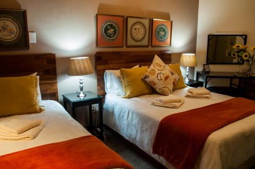 Кровать или кровати в номере Rest-a-While Guest House - Pretoria