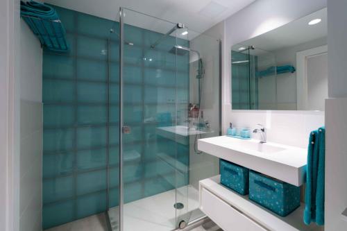 a bathroom with a glass shower and a sink at Frontline with Blue Views in Las Palmas de Gran Canaria
