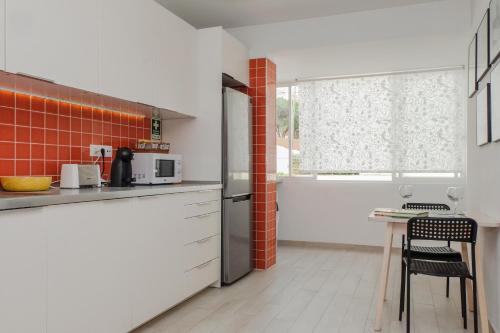 a kitchen with a refrigerator and a table at Cacao Estoril Apartment in Estoril