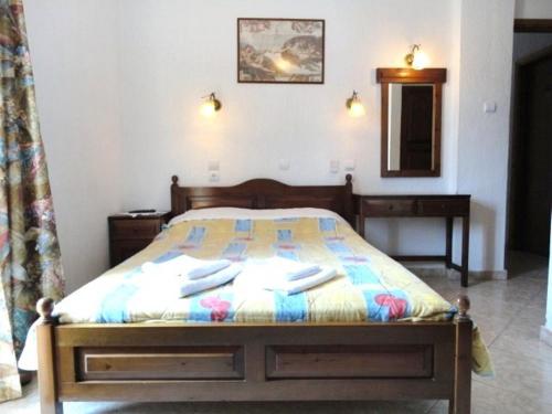 a bed with a blanket on top of it next to a lamp at Smile Stella Studios in Skopelos Town