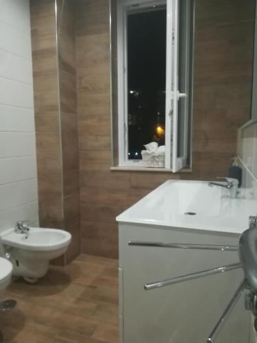 a bathroom with a sink and a toilet and a window at B&B Purple Italy in Fiumicino