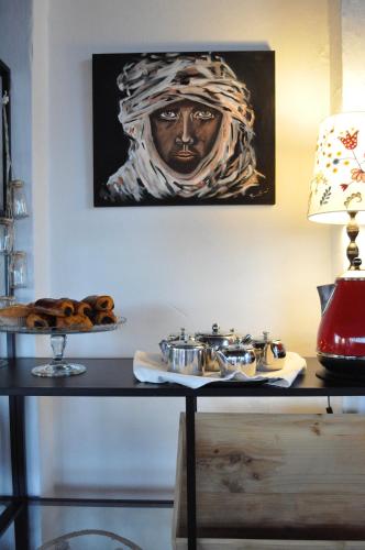 a table with a plate of food and a painting at Hotel Rural La Paloma in Villanueva de Tapia