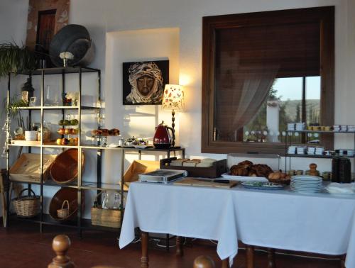 a room with a table and a shelf of food at Hotel Rural La Paloma in Villanueva de Tapia