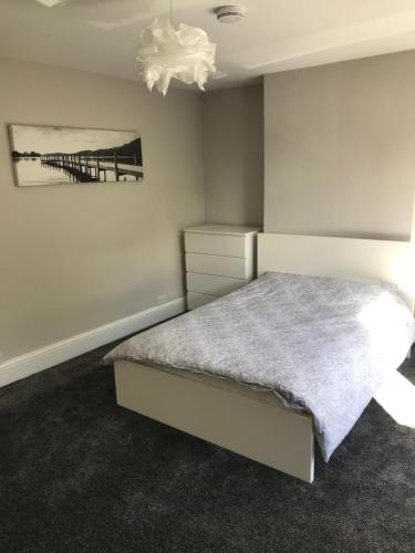 a bedroom with a bed and a painting on the wall at Two Little Ducks Guesthouse in Ellesmere Port