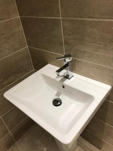 a white sink with a faucet in a bathroom at Two Little Ducks Guesthouse in Ellesmere Port