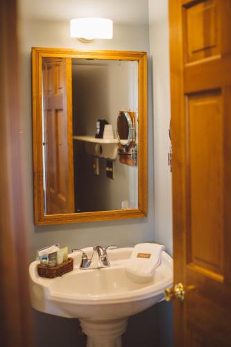 a bathroom with a sink and a mirror at Albergo Allegria Hotel & Breakfast Restaurant in Windham