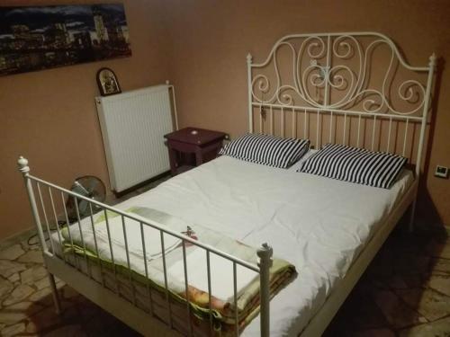 een slaapkamer met een groot wit bed met gestreepte kussens bij TS-George's apartments by the airport in Markopoulon