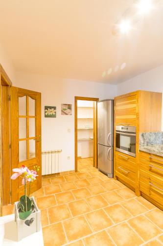 a kitchen with wooden cabinets and a tile floor at Marasolana in Jalón