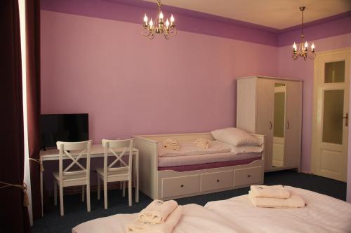 a bedroom with two beds and a desk and a table at Penzion U Lucerny in Jindřichŭv Hradec