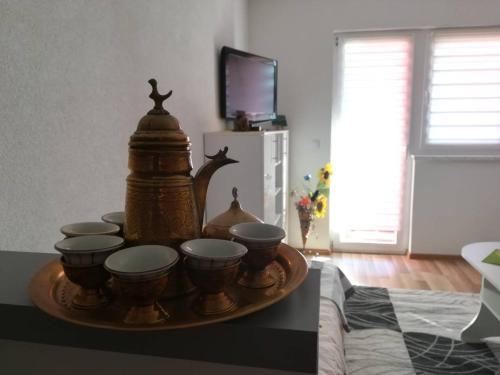a tray of bowls and cups on a table at Studio Apartman ZENICA in Zenica