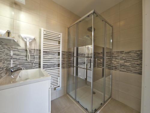 レ・ゼペスにあるHameau Colbert - 3km du PuyduFouのバスルーム(ガラス張りのシャワー、シンク付)
