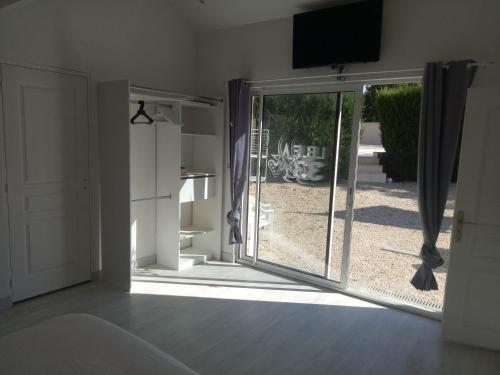 een kamer met een glazen schuifdeur en uitzicht op een tuin bij B&B le 3 étoiles 