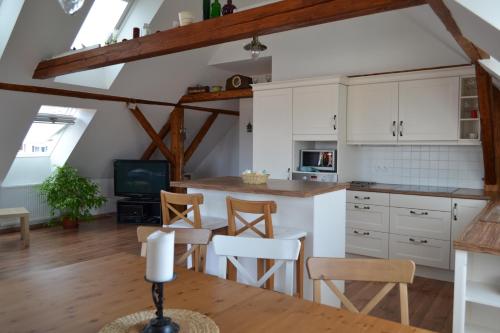 Nezdice的住宿－Apartmány Nezdice na Šumavě，厨房配有白色橱柜和桌椅