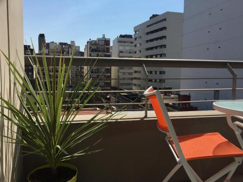 a plant in a pot on a balcony with a chair at 629 Serrano in Buenos Aires