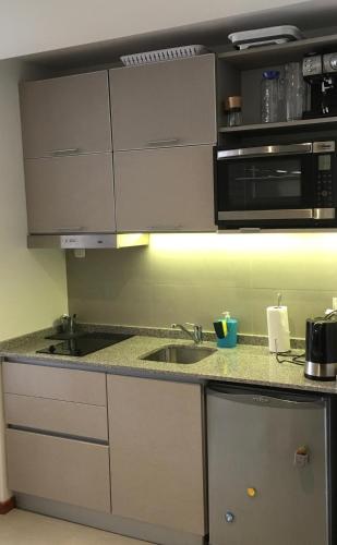 a kitchen with a sink and a microwave at 629 Serrano in Buenos Aires