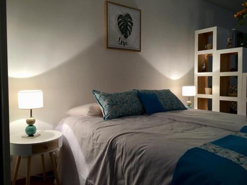 1 dormitorio con 1 cama y 1 mesa con lámpara en 629 Serrano en Buenos Aires